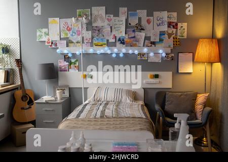 Bild des Bettes eines kranken Patienten und gezeichterte Bilder an die Wand in der Krankenhausabteilung Stockfoto