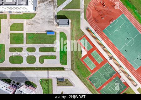 Luftaufnahme von oben auf dem Schulhof mit neuen Sportplätzen für Mannschaftsspiele des Sports. Drohne Foto. Stockfoto