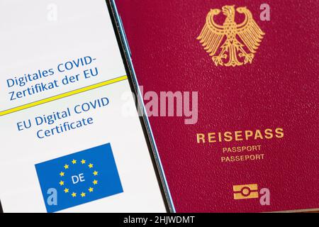 Berlin, Deutschland. 31st Januar 2022. Ein digitales COVID-Zertifikat aus der EU (l), gesehen auf einem Smartphone, liegt auf einem Tisch neben einem deutschen Pass. Wer ab Februar 1 in die EU reisen will, muss sich auf strengere Regeln vorbereiten. Die Gültigkeit der EU-Impfbescheinigungen erlischt automatisch neun Monate nach der grundlegenden Immunisierung. Um weiterhin leichter reisen zu können, muss eine Auffrischimpfung stattgefunden haben. Quelle: Fernando Gutierrez-Juarez/dpa-Zentralbild/dpa/Alamy Live News Stockfoto
