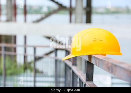 Sicherheitshardhut auf Geländer auf der Baustelle Stockfoto