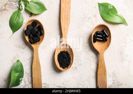 Löffel mit verschiedenen Aktivkohle-Typen auf grunge-Hintergrund Stockfoto