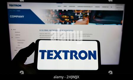 Person, die das Smartphone mit dem Logo des US-Luftfahrtunternehmens Textron Inc. Auf dem Bildschirm vor der Website hält. Konzentrieren Sie sich auf die Telefonanzeige. Stockfoto