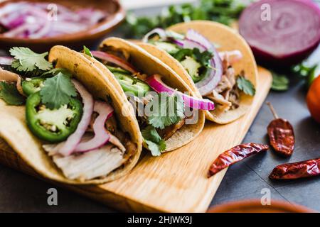 mexikanische Street Tacos Zutaten mit Schweinefleisch Carnitas, Tortillas, Avocado, Zwiebeln, Koriander in Mexiko-Stadt Stockfoto