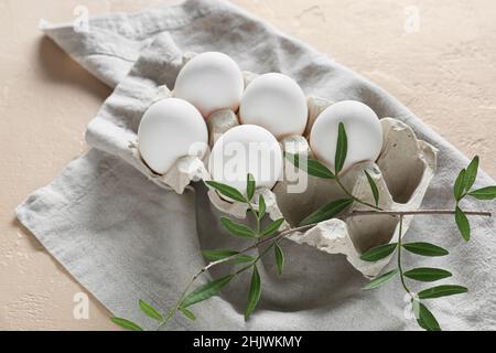 Schöne Ostereier, Äste und Serviette auf hellem Hintergrund Stockfoto