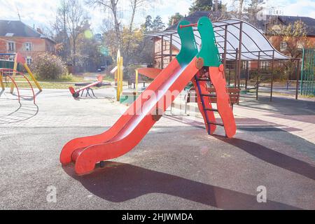 Leere Rutsche auf dem Spielplatz an einem sonnigen Herbsttag Stockfoto