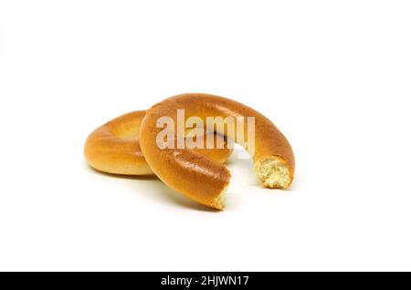 Ganze und gebissene Bagels auf weißem Hintergrund Stockfoto