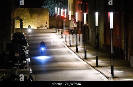 Hildesheim, Deutschland. 01st. Februar 2022. Am frühen Morgen passieren Radfahrer das Weltkulturerbe-Band zwischen Hildesheimer Dom und Michaelskirche. Quelle: Julian Stratenschulte/dpa/Alamy Live News Stockfoto