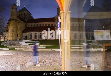 Hildesheim, Deutschland. 01st. Februar 2022. Am frühen Morgen geht ein Mann an der Kirche St. Michaelis in Hildesheim vorbei. Quelle: Julian Stratenschulte/dpa/Alamy Live News Stockfoto