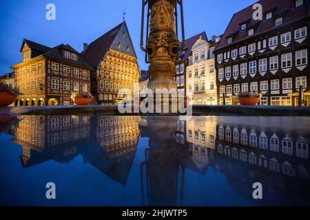 Hildesheim, Deutschland. 01st. Februar 2022. Der Marktplatz mit dem Knochenhaueramtshaus spiegelt sich in einer Pfütze wider. Quelle: Julian Stratenschulte/dpa/Alamy Live News Stockfoto