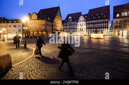 Hildesheim, Deutschland. 01st. Februar 2022. Passanten laufen am frühen Morgen über den Marktplatz mit dem Knochenhaueramtshaus. Quelle: Julian Stratenschulte/dpa/Alamy Live News Stockfoto