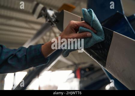 Unerkannte Frau, die spezielle Ausrüstungen verwendet, während sie in der Flugzeuggarage arbeitet Stockfoto