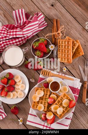 Waffeln mit Erdbeeren, Bananen und Honig. Stockfoto