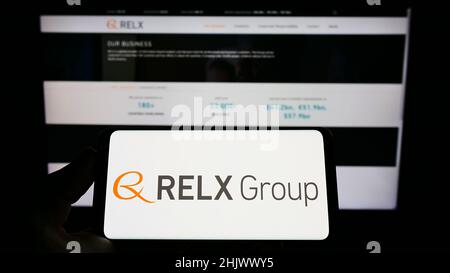 Person, die ein Smartphone mit dem Logo des britischen Analyseunternehmens RELX Group plc auf dem Bildschirm vor der Website hält. Konzentrieren Sie sich auf die Telefonanzeige. Stockfoto