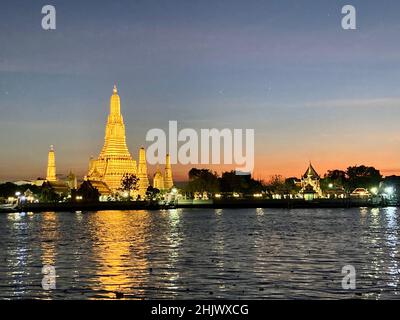 Bangkok, Thailand. 30th Januar 2022. Wat Arun, der Tempel der Morgenröte, von der anderen Seite des Chao Phraya Flusses aus gesehen. Der Tempel ist am Abend eindrucksvoll beleuchtet. Die meisten Touristenattraktionen sind noch menschenleer, aber Touristen, die den vollen Grundschutz mit dem meist notwendigen zweiten Schuss haben, können ab sofort wieder quarantfrei nach Thailand einreisen. (To dpa 'Einreisebestimmungen nach Thailand lockert sich wieder - Strafen für Straftaten') Quelle: Carola Frentzen/dpa/Alamy Live News Stockfoto