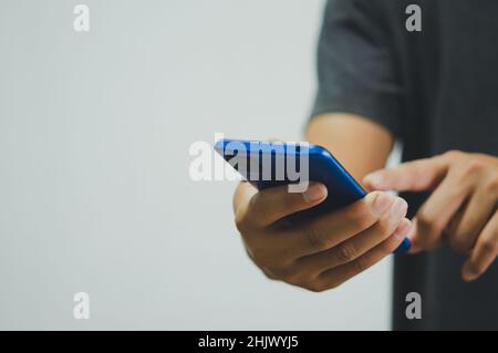 Mann mit Handy Social Media und moderne Technologie oder Online-Shopping für finanzielle Transaktionen.Copy Space Stockfoto