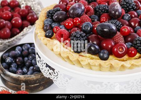 Süße Tarte mit Himbeeren, Heidelbeeren, Brombeeren, Kirschen und roten Johannisbeeren. Party-Dessert Stockfoto