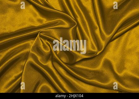 Die Textur des Satingewebes von Senf Farbe, Muster von zerknittert Linien, Draufsicht. Stockfoto