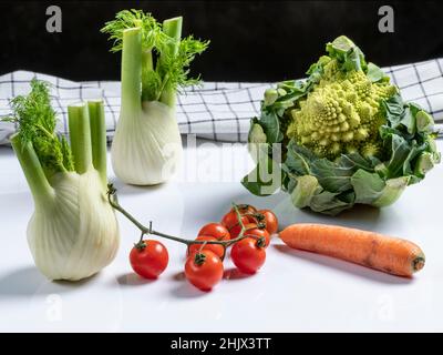 Zusammensetzung aus frischem Gemüse mit römischem Kohl, Karotten, Kirschtomaten und Fenchel Stockfoto