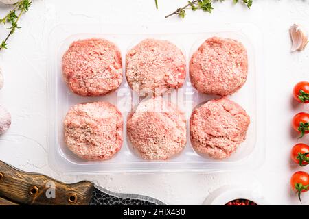 Rohe frische Hähnchenschnitzel in durchsichtigem Kunststoff-Container-Set, auf weißem Steintisch-Hintergrund, Draufsicht flach liegend Stockfoto