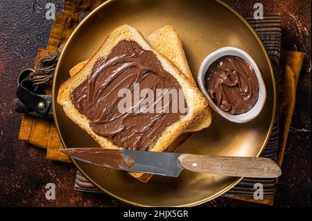Stapel von Toasts mit Schokolade Haselnuss-Creme in Teller. Dunkler Hintergrund. Draufsicht Stockfoto