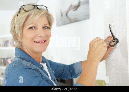 Reife Frau tut diy zu Hause Stockfoto