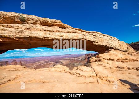 Panoramablick auf den berühmten Mesa Arch unter blauem Sommerhimmel im Canyonlands National Park, Utah Stockfoto