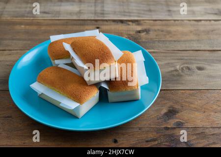 Mantecadas handgemachtes typisch spanisches Dessert. Cupcakes mit blauem Teller auf Holzhintergrund. Speicherplatz kopieren. Stockfoto