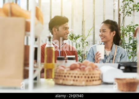 Junges Paar, das im Café zu Mittag gegessen hat, wo es Bio- und Bauernkost serviert Stockfoto