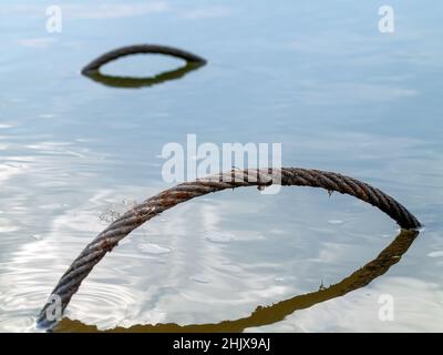 Im Sommer liegt im Fluss ein eisernes Kabel Stockfoto