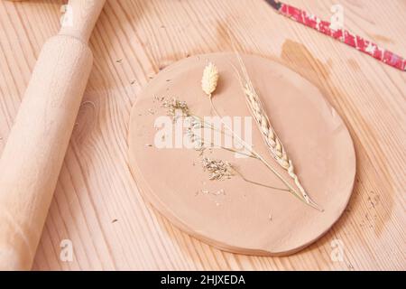 Formationsmethode der keramischen Zubereitung. Wandpaneel mit Spikeletten. Handarbeit. Herstellung von Keramik Stockfoto