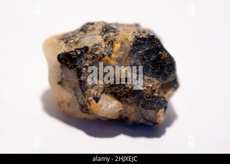 Kleiner Quarzstein mit schwarzem Biotit auf weißem Hintergrund Stockfoto