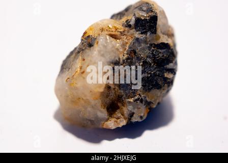 Kleiner Quarzstein mit schwarzem Biotit auf weißem Hintergrund Stockfoto