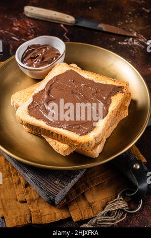 Stapel von Toasts mit Schokolade Haselnuss-Creme in Teller. Dunkler Hintergrund. Draufsicht Stockfoto