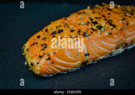 Steak mit geräuchertem Lachs, gewürzt mit schwarzem Pfeffer auf einem Schiefertablett Stockfoto