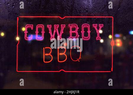 Cowboy Barbecue Neon-Schild im regnerischen Fenster Stockfoto