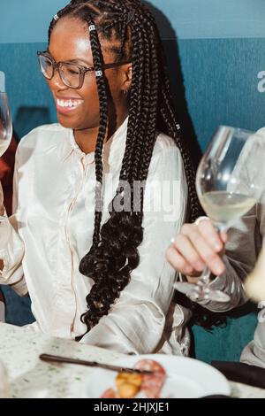Glückliche junge Frau, die in der Bar Alkohol getrunken hat Stockfoto