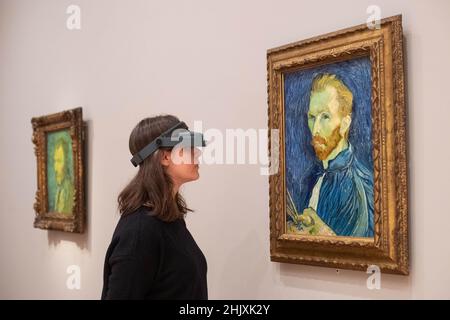 NUR FÜR REDAKTIONELLE VERWENDUNG Kuratorin Karen Serres verwendet einen Opti-Visor, um die feinen Details eines der beiden Vincent Van Gogh-Selbstporträts zu betrachten, die beide den Titel „Selbstporträt“ haben und nebeneinander in der Courtauld Gallery in London aufgehängt werden. Die letzte Vorbereitung der Galerie für eine bevorstehende Ausstellung der Selbstporträts des Künstlers, die am Donnerstag, dem 3. Februar, für die Öffentlichkeit zugänglich ist. Ausgabedatum: Dienstag, 1. Februar 2022. Stockfoto