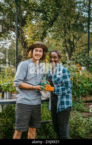 Portrait von lächelnden weiblichen und männlichen Bauern, die im Garten stehen Stockfoto