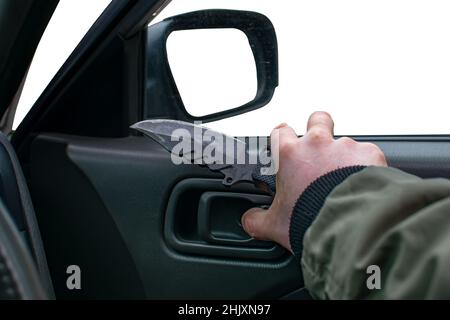 Nahaufnahme, ein Messer in der Hand eines Mannes, der auf einem leeren, sauberen weißen, isolierten Hintergrund eine Autotür öffnet Stockfoto