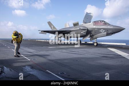 Philippine Sea, Vereinigte Staaten. 29. Januar 2022. Ein US Marine Corps F-35B Lightning II Kampfflugzeug der Marine Expeditionary Unit 31st wird während der Routinepatrouille am 29. Januar 2022 in der philippinischen See zum Start vom Flugdeck des amphibischen Angriffsschiffes USS America signalisiert. Kredit: MC3 Theodore C. Lee/Planetpix/Alamy Live Nachrichten Stockfoto