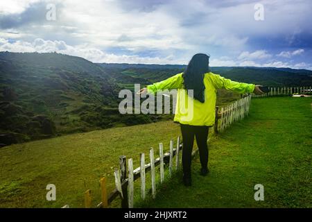 Junge Mädchen allein Reisenden isoliert auf abgelegenen Berggipfel am Morgen aus flachem Winkel Bild wird auf latilum Peak shillong meghalaya indien genommen. Stockfoto