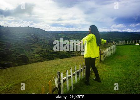 Junge Mädchen allein Reisenden isoliert auf abgelegenen Berggipfel am Morgen aus flachem Winkel Bild wird auf latilum Peak shillong meghalaya indien genommen. Stockfoto