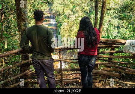 Junges Paar, das am Morgen aus dem oberen Winkel einen Wasserfall von der Bergspitze in grünen Wäldern beobachtet, wird bei den Fällen von wei sawdong cherrapunji s aufgenommen Stockfoto