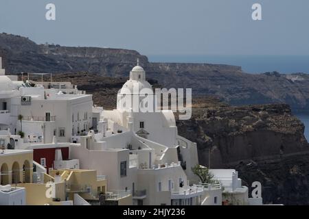 Blick auf eine traditionelle griechisch-orthodoxe Kirche und weiß getünchte Häuser in Fira Santorini, Griechenland Stockfoto