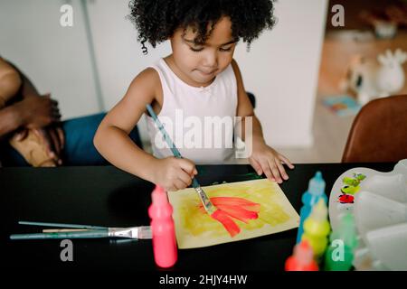 Mädchen malen auf Papier am Tisch Stockfoto