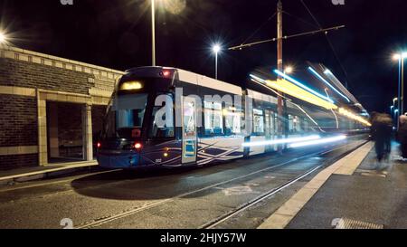 Straßenbahnen, die nachts an der Straßenbahnhaltestelle in Blackpool vorbeifahren Stockfoto