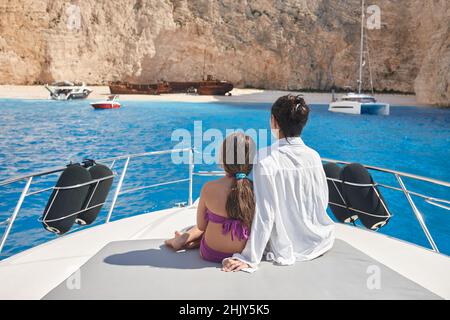 Junge Mutter mit Tochter genießt schönen Navagio Strand von Yacht Stockfoto