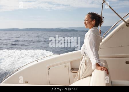 Frau auf weißer Yacht im Meer während der Sommerferien Stockfoto