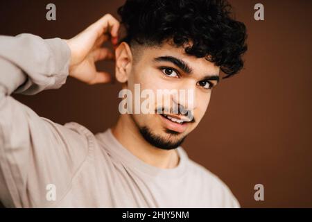 Junger Mann mit der Hand hinter dem Kopf im Studio Stockfoto