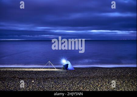 Seegangler in blauem Zelt, aufgestellt am Strand bei Flut, Rossall Beach, Fleetwood Stockfoto